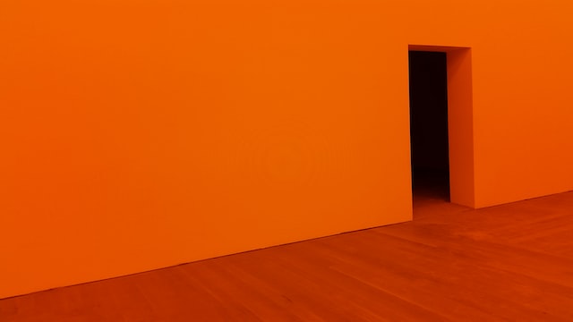 A room with orange walls and red flooring.