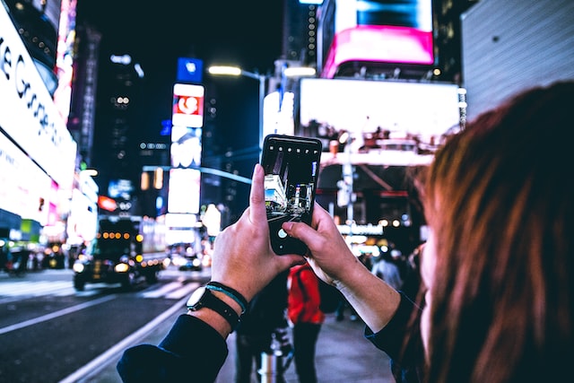 A woman taking a photo with her phone.